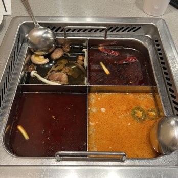 Haidilao Hotpot Flushing - Clockwise: Mala Beef Tallow, Tom Yum, Regular Mala, Mushroom broth - Hot Pot Near Me - Flushing, New York