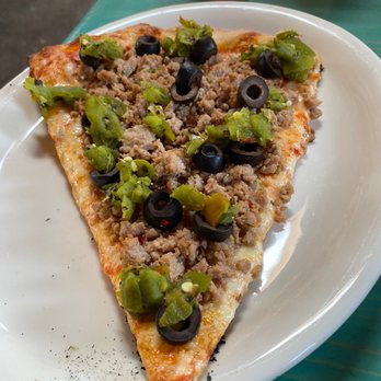 Pizanos - A slice of Italian sausage, green chili and black olives - Pizza Near Me - Taos, New Mexico