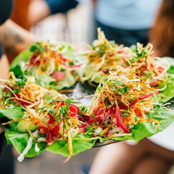 Dos Santos - a person holding a plate of salad - Mexican Near Me - Denver, Colorado