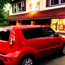 a red car parked in front of a restaurant a red car parked in front of a restaurant
