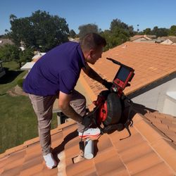 Patterson Property Inspections - Inspector performing sewer scope on roof
