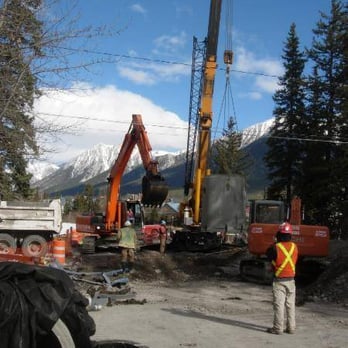 Mini Dig Corp - a man standing in front of a construction site - General Contractors Near Me - Calgary, Alberta