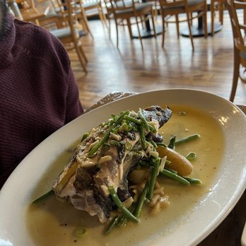 The Tipsy Trout - Trout - A dish featuring a cooked fish fillet topped with chopped vegetables and herbs, served with a sauce on a white plate in a restaurant setting. - American Near Me - Basalt, Colorado
