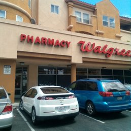 two cars parked in front of a pharmacy walgree