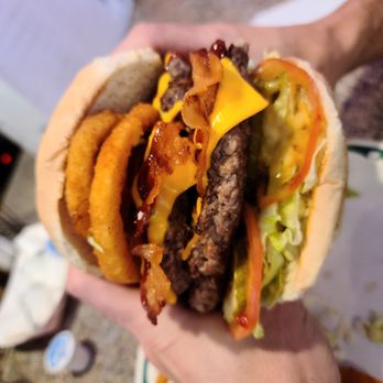 Cutthroat Cafe - a person holding a hamburger and french fries - Breakfast & Brunch Near Me - Bailey, Colorado