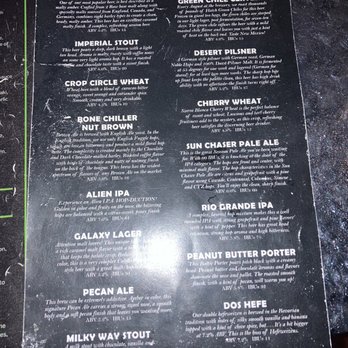 Alien Brew Pub - Draft Menu - A black menu lists different draft beers at Alien Brew Pub, including descriptions and alcohol content, with a space-themed design. - Burgers Near Me - Albuquerque, New Mexico
