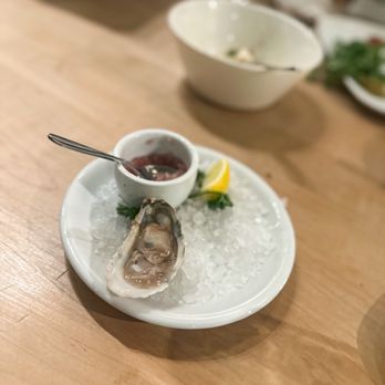 Caviste - a plate of oysters and a bowl of sauce - Wine Bars Near Me - Winston Salem, North Carolina