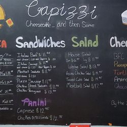 Capizzi's Cheesecake-Pizza and then some - Capizzi Cheesecake...and then some. Blackboard menu. They have pizza, sandwiches, salad, cheesecakes, and paninis.