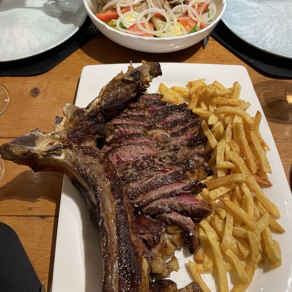 Asador Indusi - The steak sliced up with french fries the salad is on the side - Bilbao, BI