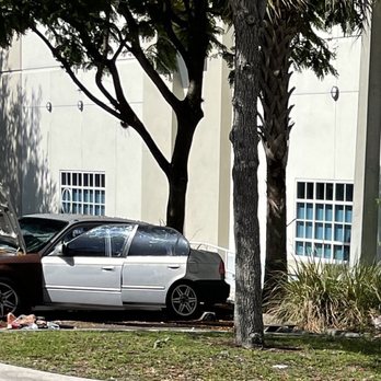 CVS Pharmacy - Car being dismantled and worked on by half dressed man in parking lot - Drugstores Near Me - Fort Lauderdale, Florida