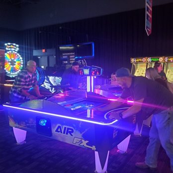 Dave & Buster's Florence - a group of men playing air hockey - Arcades Near Me - Florence, Kentucky
