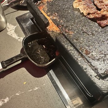 Champs Korean BBQ - Griddle a bit slantend and thats where the grease goes on that small cast iron - Korean Near Me - San Diego, California Champs Korean BBQ - Griddle a bit slantend and thats where the grease goes on that small cast iron - Korean Near Me - San Diego, California
