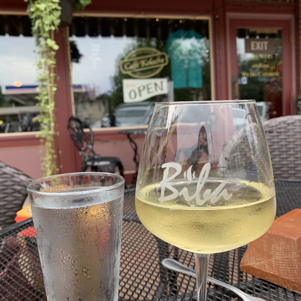 a glass of white wine on a table outside