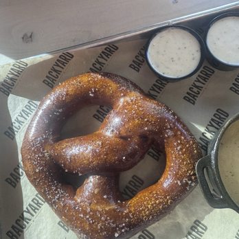Backyard - Desert Ridge - Large pretzel for sharing with cheese sauce - Sports Bars Near Me - Phoenix, Arizona Backyard - Desert Ridge - Large pretzel for sharing with cheese sauce - Sports Bars Near Me - Phoenix, Arizona