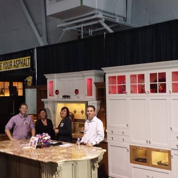 Barry's Kitchens - a group of people standing around a kitchen island - Cabinetry Near Me