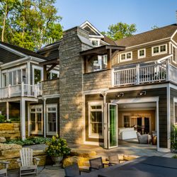 The Cleary Company - Home addition - lower level sunroom with deck above featuring 2 story fireplace, outdoor kitchen and folding glass walls.