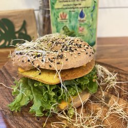Botanika Cafe - SOURDOUGH HOUSE MADE BAGEL WITH TOMATO, LETTUCE, MASHED AVOCADO AND MUNG BEANS OMELETTE.