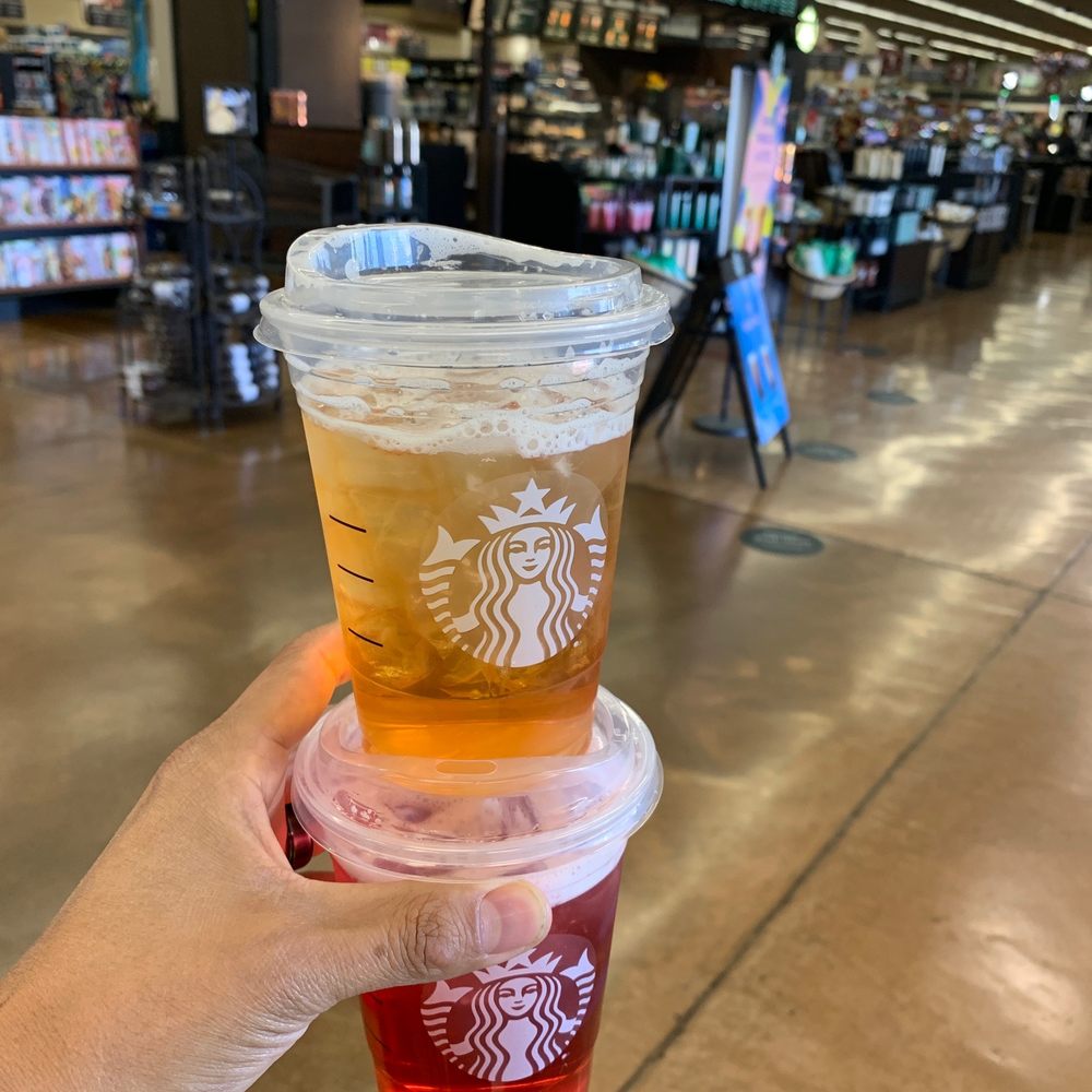a hand holding two cups of iced coffee a hand holding two cups of iced coffee