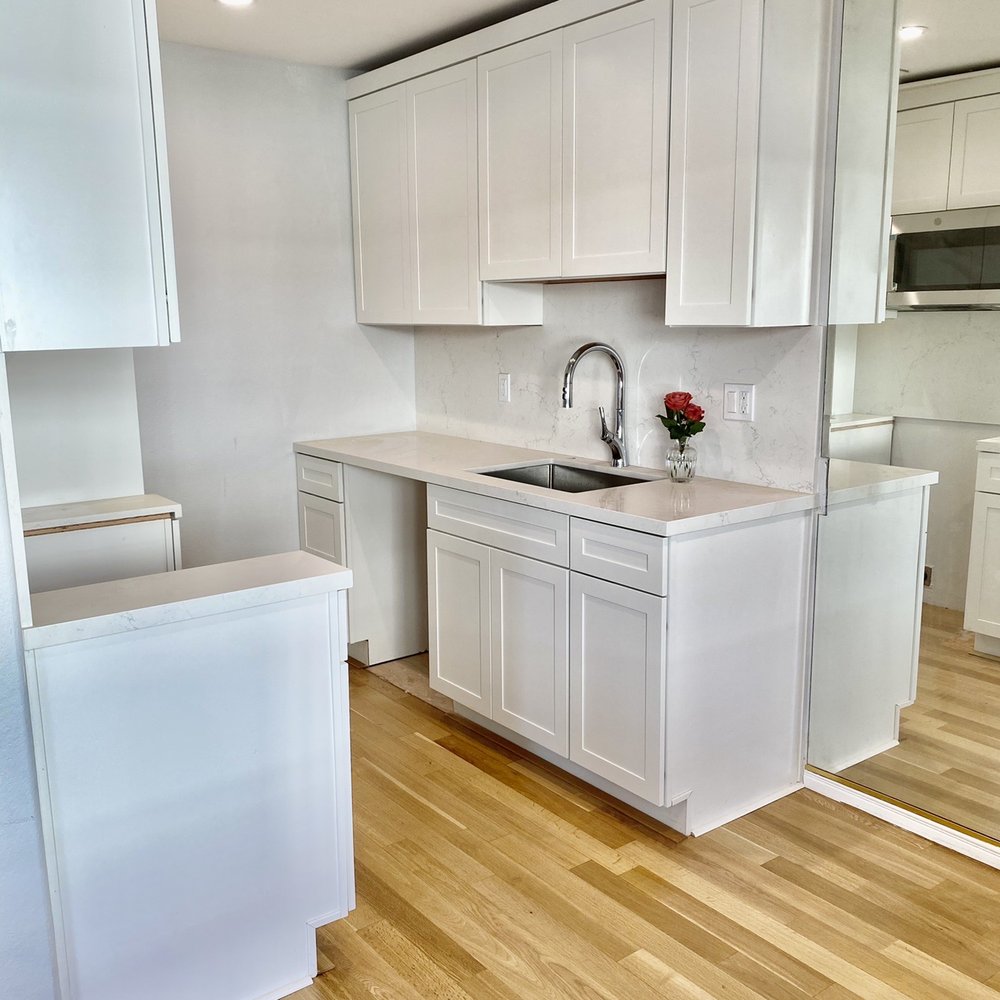TS Construction - a kitchen with white cabinets and wood floors - General Contractors Near Me - Tarzana, California