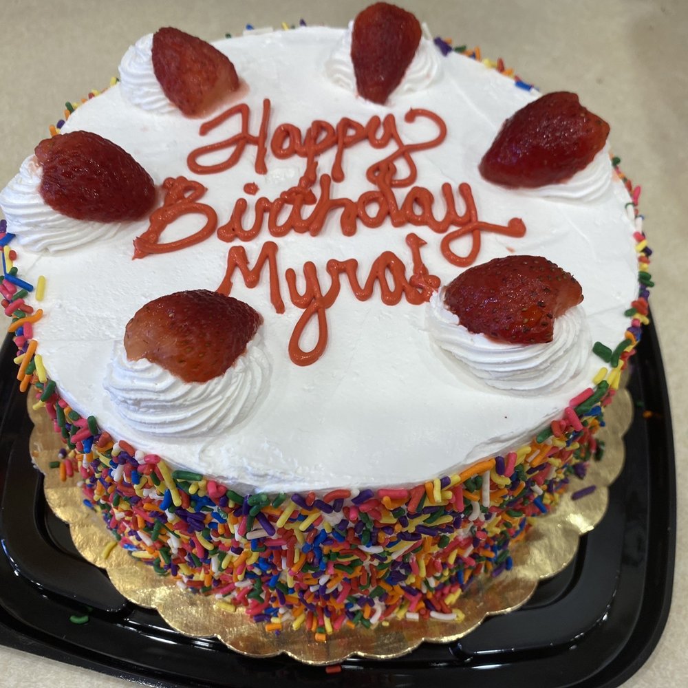 a birthday cake with strawberries and sprinkles