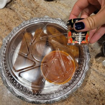 Nino's Pizza & Restaurant - a person putting sauce in a pan - Pizza Near Me - Harrison, New Jersey Nino's Pizza & Restaurant - a person putting sauce in a pan - Pizza Near Me - Harrison, New Jersey