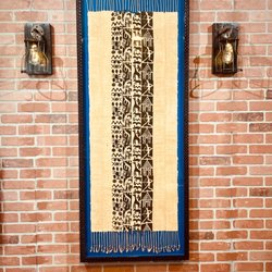 Jack's Art Gallery - Custom framing of a Ghanaian scarf on brick interior wall