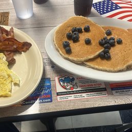 Blueberry's on pancakes scrambled eggs with bacon