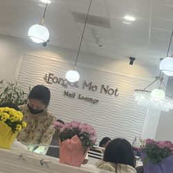 ForGet Me Not Nail Lounge - The sign inside. Front desk with comfy waiting area.