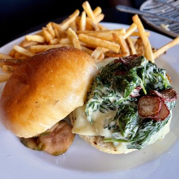 The Lake Room - The Steakhouse Burger garnished with lemon spinach and fried radish chips, brioche bun; house frittes - New American Near Me - Navarre, Minnesota The Lake Room - The Steakhouse Burger garnished with lemon spinach and fried radish chips, brioche bun; house frittes - New American Near Me - Navarre, Minnesota