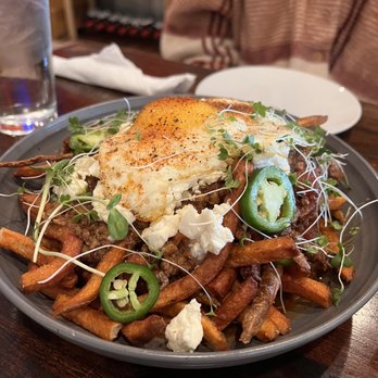 1608 Crafthouse - Poutine with chilli sauce and cheese curds and over medium egg on top - Gastropubs Near Me - Virginia Beach, Virginia 1608 Crafthouse - Poutine with chilli sauce and cheese curds and over medium egg on top - Gastropubs Near Me - Virginia Beach, Virginia