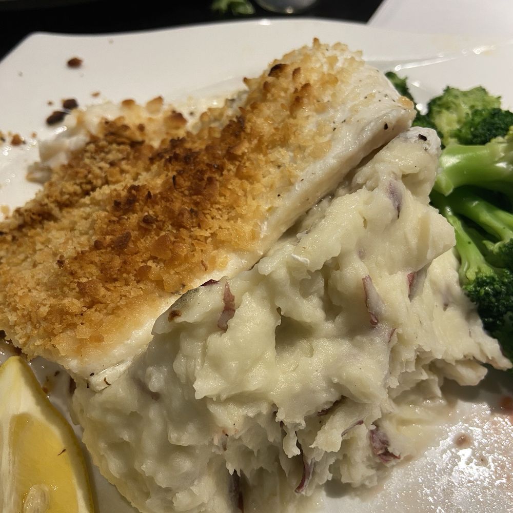 Big piece of haddock cleaned up on red mashed potatoes with broccoli crowns Big piece of haddock cleaned up on red mashed potatoes with broccoli crowns