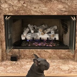 Dog enjoys warming by the fire.