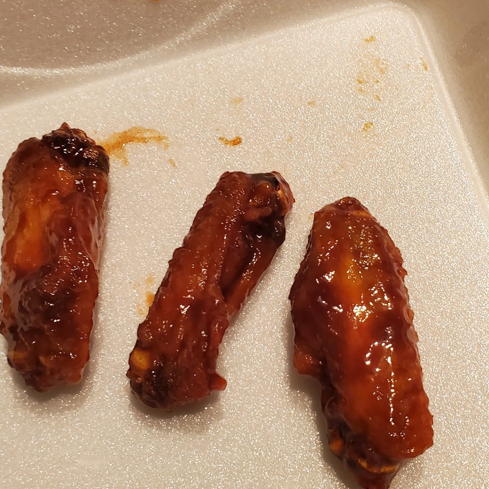 three pieces of chicken wings on a tray three pieces of chicken wings on a tray