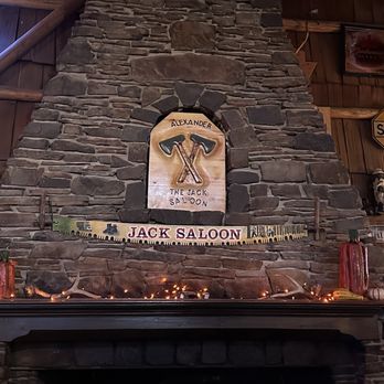 The Jack Saloon - Fireplace, logo and saw. - Bars Near Me - Lolo, Montana