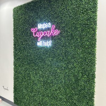 Smallcakes Lantana - a green wall with a neon sign - Desserts Near Me - Double Oak, Texas Smallcakes Lantana - a green wall with a neon sign - Desserts Near Me - Double Oak, Texas