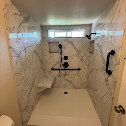 Shugarman's Bath - Tub to shower conversion with a low threshold shower pan, a ramp for wheelchair access, custom niche, a window, calcutta marble walls