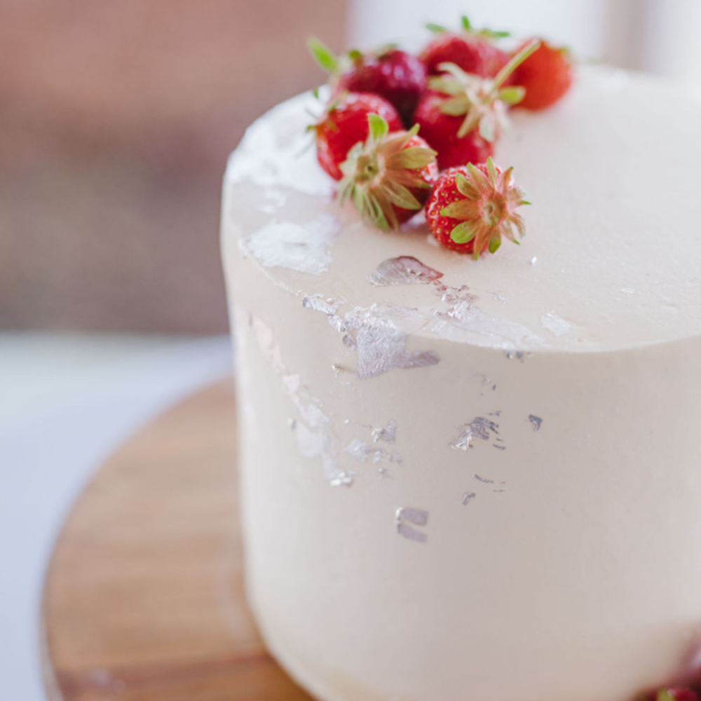 Jenny's Wedding Cakes - a white cake with strawberries on top - Desserts Near Me