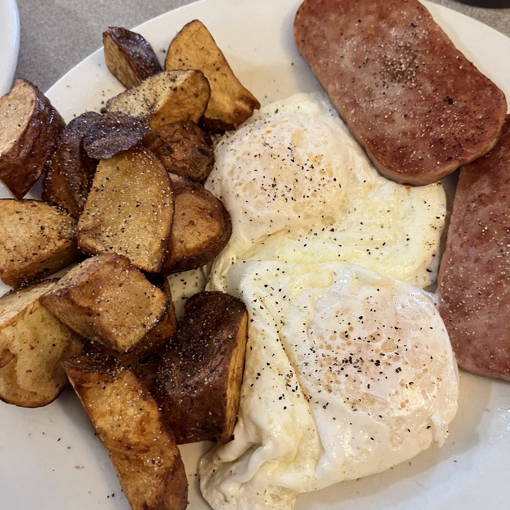 Eggs over easy with fried pan fries and spam. (Yes spam.)
