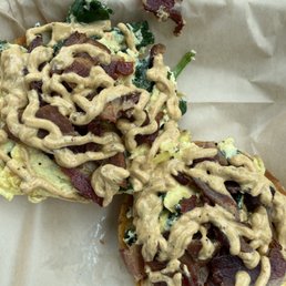 Plain bagel with scrambled egg, bacon, sautéed spinach, and chipotle crema Plain bagel with scrambled egg, bacon, sautéed spinach, and chipotle crema