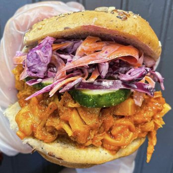 New Roots Meals - a hand holding a sandwich - Food Delivery Services Near Me New Roots Meals - a hand holding a sandwich - Food Delivery Services Near Me