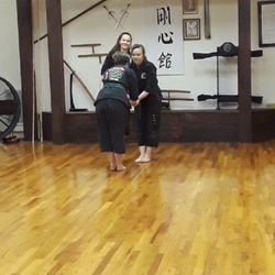Art of Martial Arts East - Sempai Luttrell being congratulated by her Sensei after passing her brown belt test