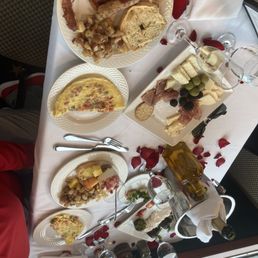 Omelette, toasted bagel, fried potatoes, bacon, charcuterie spread, champagne, & chocolate covered strawberries.