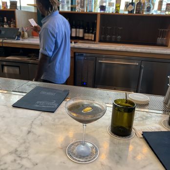 Bar Hustle - a man in a blue shirt behind a bar counter - Cocktail Bars Near Me - Memphis, Tennessee