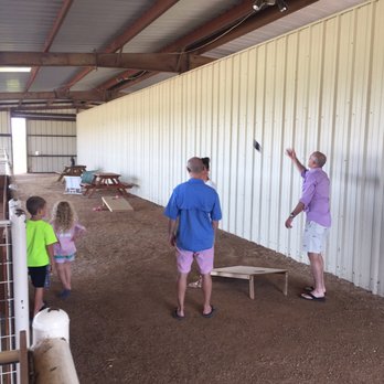 White Fox Vineyards - a man and two children in a barn - Music Venues Near Me - Murchison, Texas