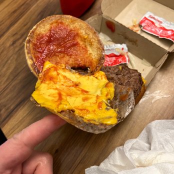 McDonald's - a hand holding a half eaten breakfast sandwich - Fast Food Near Me - Oakley, California