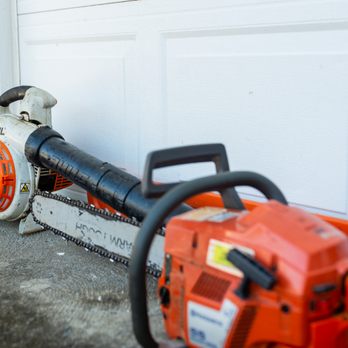Ulett Tree & Landscaping - a chainsaw leaning against a garage door - Landscaping Near Me Ulett Tree & Landscaping - a chainsaw leaning against a garage door - Landscaping Near Me