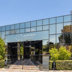 Optimize Financial - The building is a three-story structure, with walls made entirely of glass, providing a clear and unobstructed view of the surrounding area.