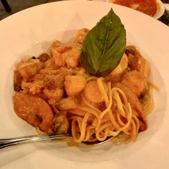 Flavio Restaurant DC - A pasta dish with chunks of seafood and a basil leaf on top, served on a white plate at Flavio Restaurant in Washington, DC. - Italian Near Me - Washington, DC, District of Columbia
