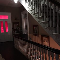 Mansion on Main B & B - Second floor landing and stairway to third floor. The red glow is from windows in the stairway leading to the servants quarters.