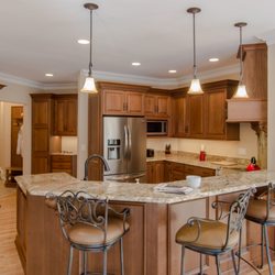 Dream Kitchens - Stained cabinetry with granite countertop and large bar height seating area.